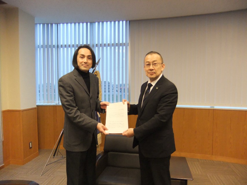 答申書の受け渡しをする吉岡会長と江里口市長の写真