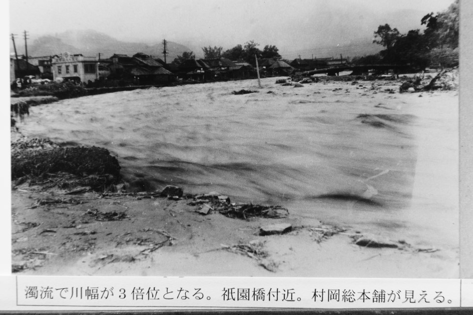 濁流で川幅が3倍くらいとなる。祇園川付近。村岡総本舗が見える。